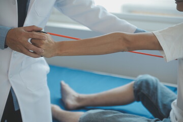 Doctor or physical therapist examines back pain and spinal area to give advice within the rehabilitation center.