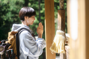 一人旅をする若い日本人女性/バックパッカー/神社にお参りをする