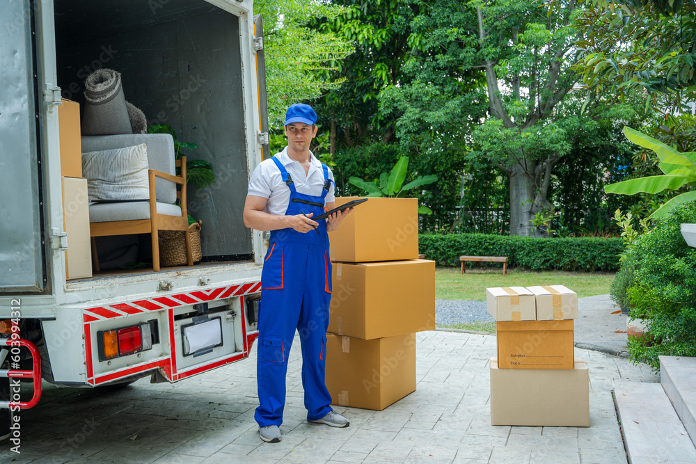 Poster House moving service worker unloading boxes and checking list before sending them to the homeowner.