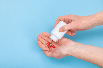 A woman takes medicine. Female hands hold capsules or pills. Treatment, taking vitamins, healthcare
