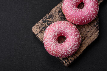 Delicious fresh sweet donuts in pink glaze with strawberry filling