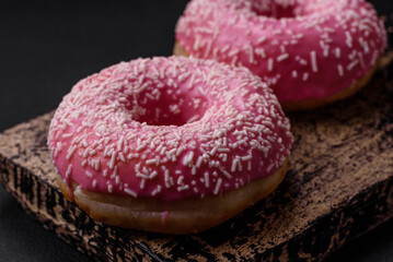 Delicious fresh sweet donuts in pink glaze with strawberry filling