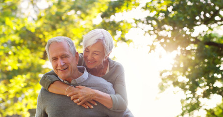 Senior couple, piggy back and happy outdoor at a park with love, care and support. A elderly man and woman in nature for a fun walk, quality time and healthy marriage or retirement while playful