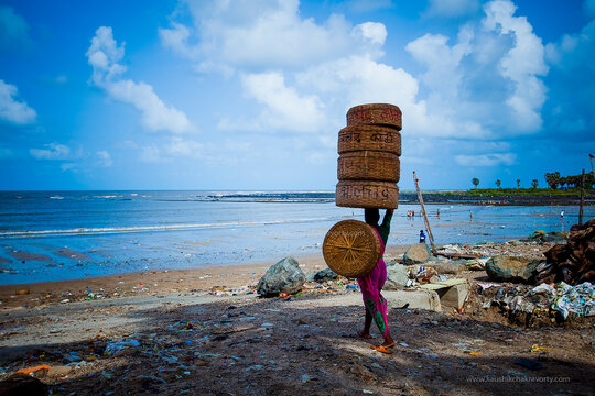 Fisher women carrying empty baskets on the head, walking on the beach. 