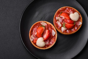 Delicious fresh sweet tartlets with strawberries and coconut flakes