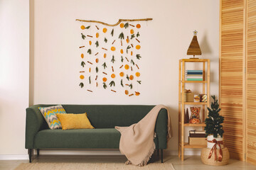 Stylish room interior with sofa and handmade dry orange decor