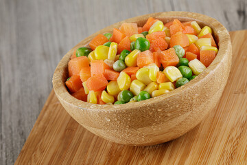 Close up of a wooden bowl of delicious mixed vegetables