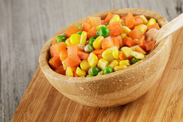 Close up of a wooden bowl of delicious mixed vegetables