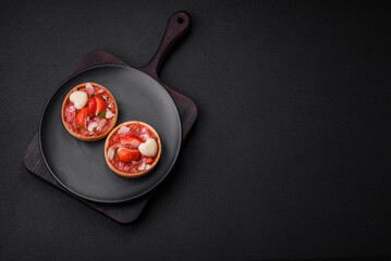 Delicious fresh sweet tartlets with strawberries and coconut flakes