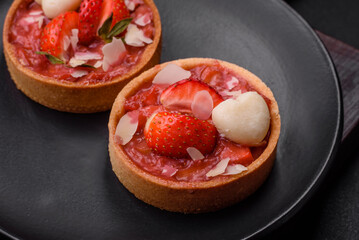 Delicious fresh sweet tartlets with strawberries and coconut flakes