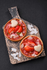 Delicious fresh sweet tartlets with strawberries and coconut flakes