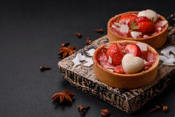 Delicious fresh sweet tartlets with strawberries and coconut flakes
