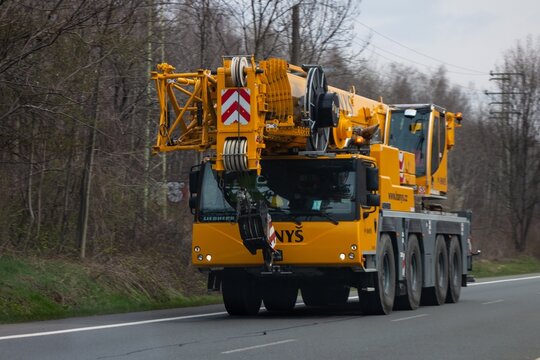 Liebherr LTM 1120-4.1 crane of Hanys rental company with strong motion blur effect focused on the boom head