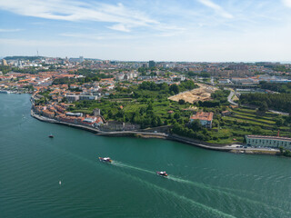 Fototapeta na wymiar Aerial view of the Douro River in Porto. Aerial drone view of the city of Porto in Lisbon, the image includes bridges, riverside and the typical houses of the city, fado gaia