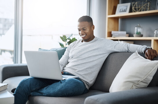 Black man relax on couch with laptop, streaming online in living room and subscription service with internet. Technology, connectivity and happy male person chill at home watching tv show or film