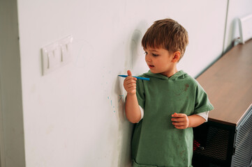 Naughty child drawing the wall of his house - obrazy, fototapety, plakaty