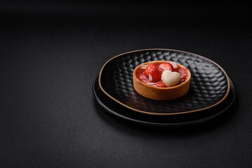 Delicious fresh sweet tartlets with strawberries and coconut flakes