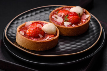 Delicious fresh sweet tartlets with strawberries and coconut flakes