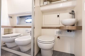 yacht Interior of a modern bathroom with white bathtub and toilet. Nobody inside