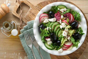 Lettuce salad, cucumber, radish salad with cottage cheese and flax seeds olive oil salad on old wooden background. Healthy diet food. Diet menu and balanced diet. Top view.