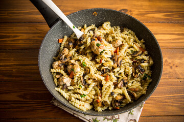 vermicelli cooked with mushrooms, meat and vegetables in a frying pan