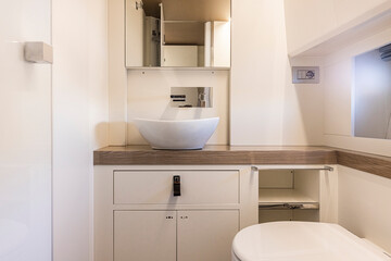 yacht Interior of a modern bathroom with white bathtub and toilet. Nobody inside - 604003119