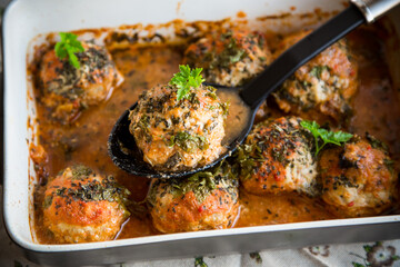 cooked meatballs from minced meat in a sauce in a ceramic form