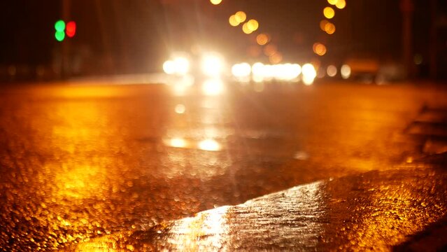Cars start moving on a very large city road at night after rainfall. In the frame you can see a lot of car headlights.
