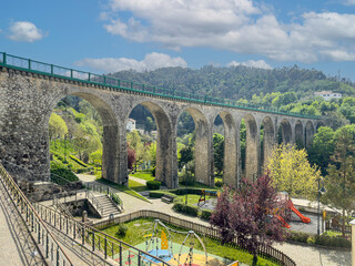 Old railway bridge and garden in Vouzela, Viseu, Portugal, on a sunny afternoon. - obrazy, fototapety, plakaty
