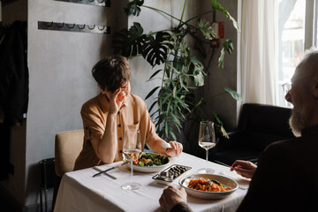 Laughing mature couple eating lunch in cafe