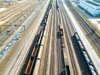 Fototapeta na wymiar Cargo trains close-up. Aerial view of colorful freight trains on the railway station. Wagons with goods on railroad. Heavy industry. Industrial conceptual scene with trains. Top view from flying drone