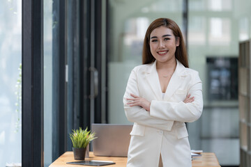 Fototapeta premium Confident Asian businesswoman arms crossed thinking of new ideas at the office. Looking at the camera. 
