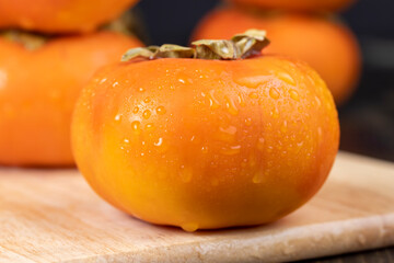 Ripe orange persimmon covered with drops