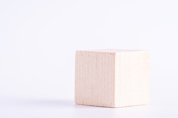 Wooden cube of natural color on white background. One blank box, macro photo.