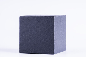 Black wooden cube on white background. One black blank box, macro photo.