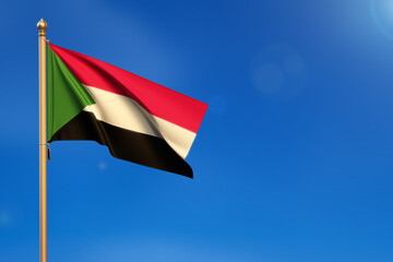 Sudan. Flag blown by the wind with blue sky in the background.