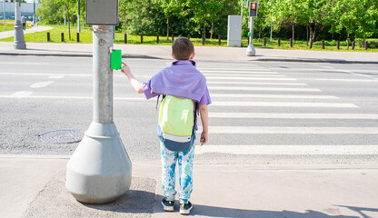 the boy presses the traffic light button, stands in front of the pedestrian crossing, is about to...