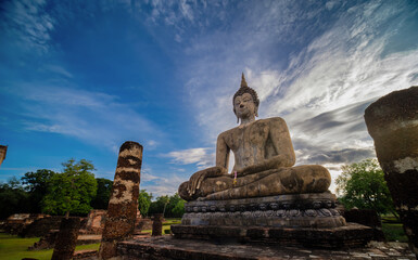 Fototapeta premium Wide view of sitting Buddha at sunset with blue sky and white cloud on background. UNESCO and World Heritage site. Travel concept.