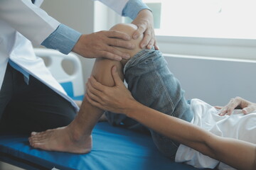 Doctor or physical therapist examines back pain and spinal area to give advice within the rehabilitation center.