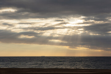 Fototapeta na wymiar landscape of sunrise or sunset on the beach, the sun's rays breaking through the clouds