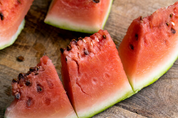 A cut piece of ripe red watermelon with seeds