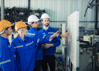 A group of robotic engineers collaboratively brainstorms and discusses ideas with cross-functional teams on a whiteboard to create strategies and solutions to make the working process more efficient.