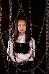Portrait of lovely stylish teen girl wear retro style image posing in dark industry room with chains, looking up. Pensive lovely girl model actress. Fashionable chic style concept. Copy ad text space