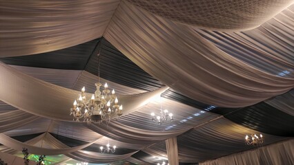 Yellow lamped chandelier on the ceiling light grey decorations in wedding party