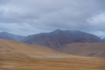Fototapeta na wymiar Landscape of Desert mountains against clouds sky at the way from Pangong Lake to Tso Moriri, Leh, Ladakh, Jammu and Kashmir, India