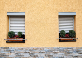 Fototapeta na wymiar window of a house with closed blinds and plants