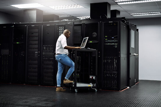 IT support, black man or coding on computer in server room for big data, network glitch or digital website. Code, fixing or technician typing on laptop testing UX, programming or software development