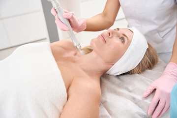 Obraz na płótnie Canvas Patient is located on cosmetology couch for laser skin resurfacing procedure