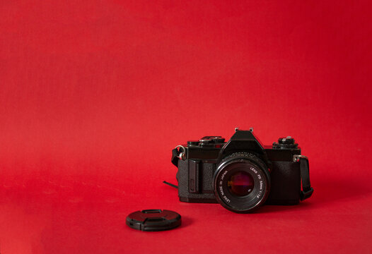 Analog film camera on red background