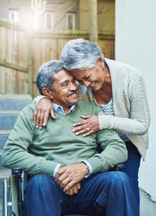 Disability, wheelchair and senior couple hug with care, support and love by elderly happy people in...